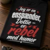 Sort t-shirt med teksten Jeg er en enspænder, Dottie – en rebel med humor i retro typografi med diskrete rebeldetaljer.
